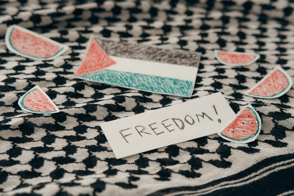 Kondisi Terkini Gaza: Krisis Kemanusiaan Membumbung di Tengah Pelanggaran Gencatan Senjata Palestinian flag and freedom note on keffiyeh surrounded by watermelon symbols.