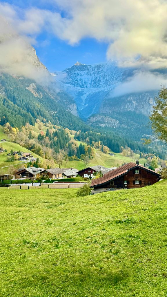 Beautiful view of Grindelwald village surrounded by lush greenery and majestic Alps.